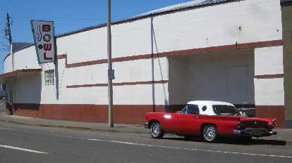 A red and white 1950s Ford Thunderbird in front of the Lower Columbia Bowl in Astoria, Oregon. red 1950s Ford Thunderbird, white top, Lower Columbia Bowl, Astoria, Oregon