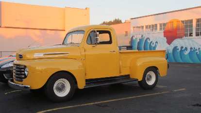 vintage yellow Ford pickup truck, blue wave mural, Astoria, Oregon