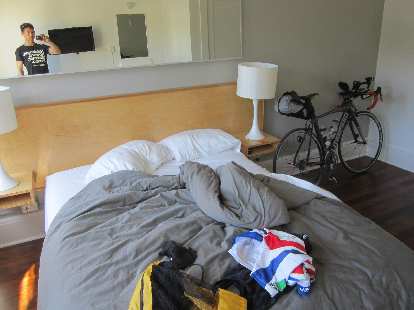 The cabin I stayed in at the Norblad Hotel with my cycling clothes on the bed and my assembled Litespeed Archon C2 against the wall. (05 Jun 2015) Norblad Hotel, cabin, cycling clothes, black 2010 Litespeed Archon C2, Trans Am Bike Race