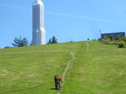 A cyclist walking up a hill to the Astoria Column. A cyclist walking up a hill to the Astoria Column.