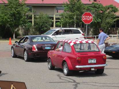 A 1960s Fiat following a Maserati Quattroporte.