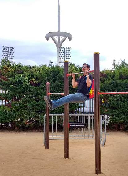 Felix Wong doing pull-ups wearing a backpack in front of the Olympic Stadium in Barcelona, Spain.