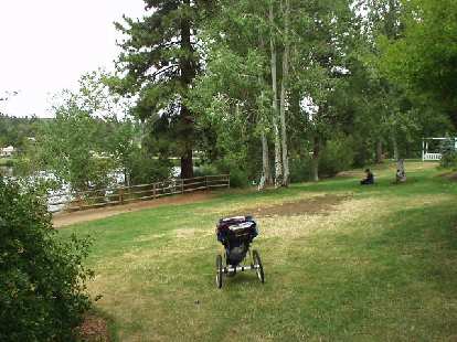 A woman meditates in Drake Park while a baby in a carriage sits idly by.