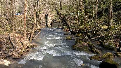 Water gushing from the Blanchard Springs through a circular hole in a pedestrian bridge. Water gushing from the Blanchard Springs through a circular hole in a pedestrian bridge.