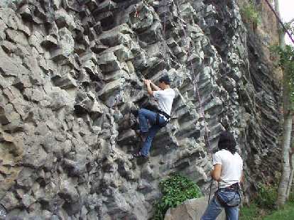 Felix Wong gives the 5.11a a try while Caesar belays. Felix Wong gives the 5.11a a try while Caesar belays.