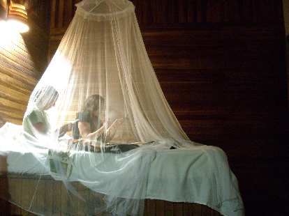Tori and Raquel under mosquito netting back at the Kelly Creek Hotel in Cahuita.