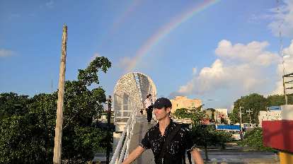 Felix Wong, black shirt, blue cap, rainbow, central Cancún, sunny morning