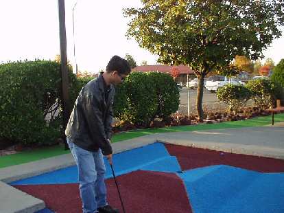 Felix, the Tiger Woods-beater (not), showing Carolyn how it's done (again, not) at Golfland in Stockton.