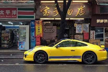 A yellow Porsche 911 with red and blue stripes.
