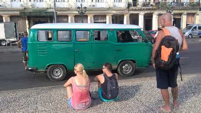 A green 1960s Volkswagen Bus with white top in front of Hotel Inglaterra in Havana, Cuba. (07 Jan 2017) A green 1960s Volkswagen Bus with white top in front of Hotel Inglaterra in Havana, Cuba.
