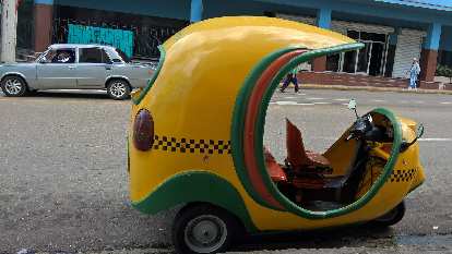 A yellow/green three-wheeled taxi in Havana, Cuba. (08 Jan 2017) A yellow/green three-wheeled taxi in Havana, Cuba.