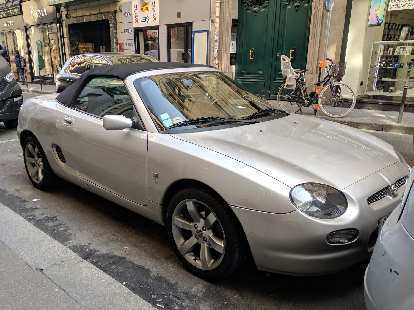 A silver MGF convertible parked on a street in Paris. A silver MGF convertible parked on a street in Paris.