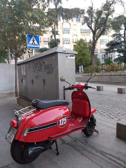 A red scooter with a black stripe and number 125.