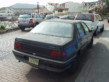 A late 80s or early 90s Peugeot 405 sedan in the French Quarter.