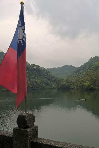 Taiwanese flag and ducks on a lake near the Cihu Mausoleum.