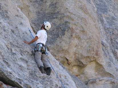Felix Wong scanning the rock above and pondering his next move after clipping a bolt.