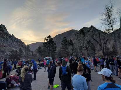 Runners in the starting area of the 2019 Colorado Marathon, with the sun starting to rise about the mountains of the Poudre Canyon.