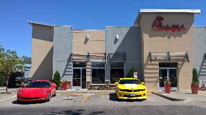 A red C6 Corvette and yellow Chevrolet Camaro (not part of the show( in front of Chik-fil-A in Fort Collins.