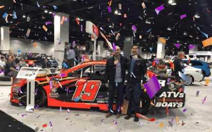 Manuel and Felix with a Toyota NASCAR race car. Manuel and Felix with a Toyota NASCAR race car.