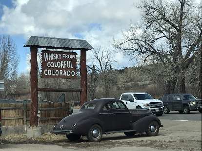 A dark deuce coupe by a Whisky from Colorful Colorado sign in Lyons, Colorado.