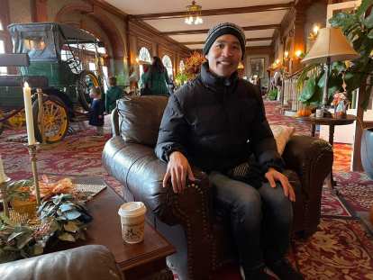 Felix sitting in a chair next to a cup of coffee inside the Stanley Hotel.