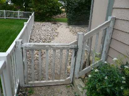 An "before" shot of the front of the side gate and fence.