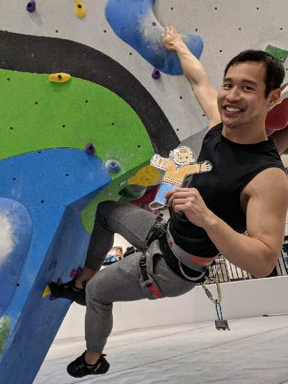 Felix bouldering with Flat Stanley inside the new Whetstone climbing gym.
