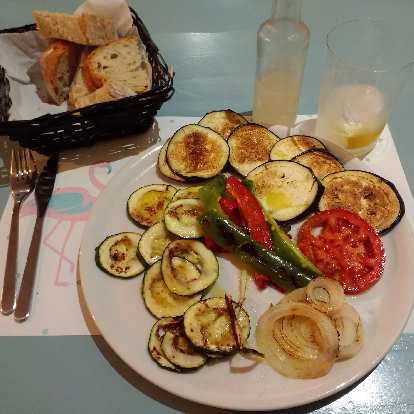 Bread and vegetables (cucumbers, onions, and tomatoes) grilled in olive oil and garlic in a nice restaurant in Nueva, Spain. (01 Oct 2017) Bread and vegetables (cucumbers, onions, and tomatoes) grilled in olive oil and garlic in a nice restaurant in Nueva, Spain.