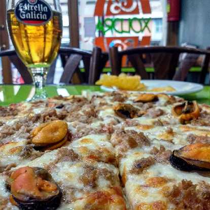 Pizza and Estrella Galicia beer at Xoldra Pizzeria in Melide, Spain. (09 Oct 2017) Pizza and Estrella Galicia beer at Xoldra Pizzeria in Melide, Spain.