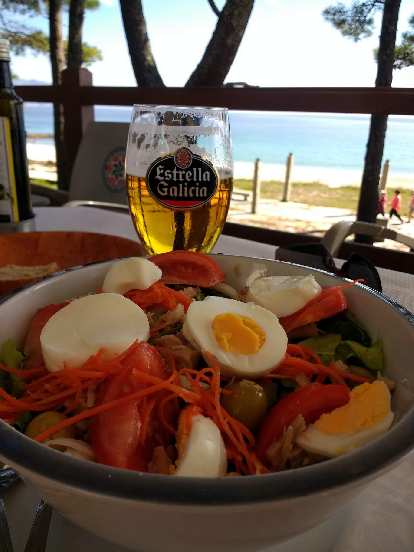 Una ensalada mixta (including eggs, tomatoes, carrots, tuna, and spinach) with a beer in Fisterra, Spain.