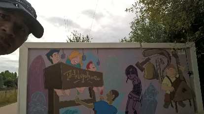 Felix Wong and a "Telephone" mural along the Power Trail in Fort Collins.