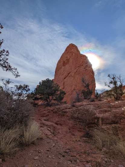 The sun going down behind a big rock at the Garden of the Gods.