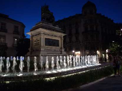 Fountain and statue at the Plaza de Isabel La Católica in Granada, Spain at night.