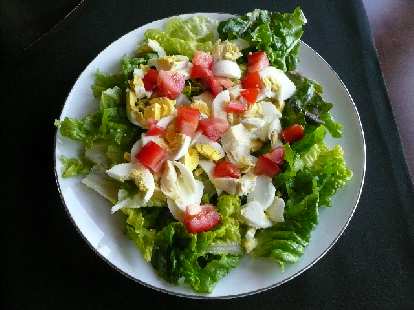 Green lettuce, hard-boiled eggs, tomatoes and artichoke pieces.