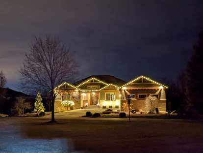A big house in the Hearthfire neighborhood with elegant white Christmas lights.