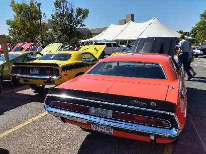 A yellow Plymouth Barracuda with an orange Dodge Challenger.