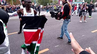 After finishing, Kipchoge ran around with the Kenyan flag. He missed slapping my outstretched hand in this photo. After finishing, Kipchoge ran around with the Kenyan flag. He missed slapping my outstretched hand in this photo.