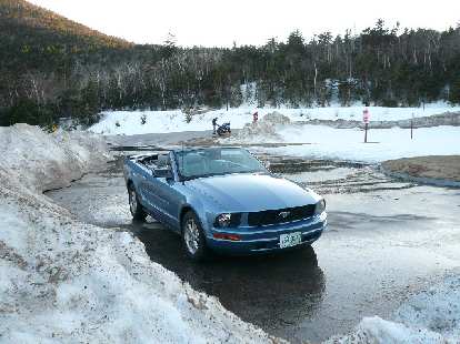 The Mustang takes a breather at a scenic overlook while a motorcyclist on a Suzuki GSX-R pulls up.