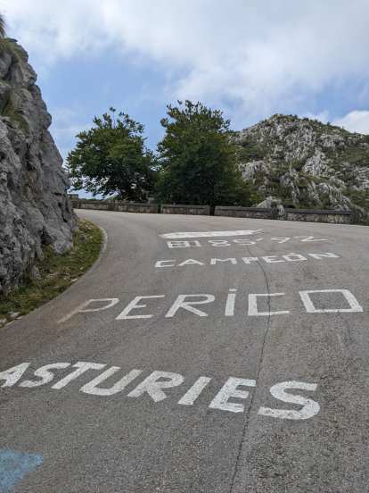 Uphill road marked in white words "Asturies Perico Campeón 8185'92"