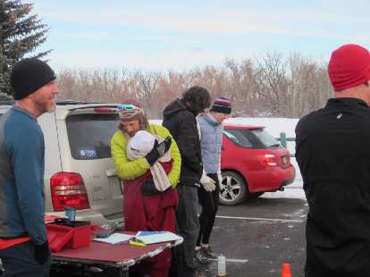 Race director Nick looking at the start times while keeping his newborn Stella warm.