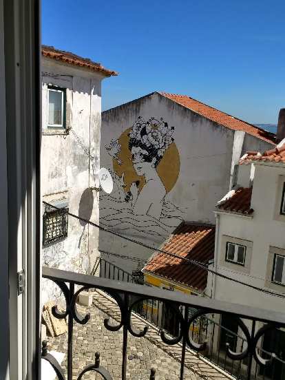 On the side of a building, a drawing of a woman in the sea with the sun behind and bird in front. On the side of a building, a drawing of a woman in the sea with the sun behind and bird in front.