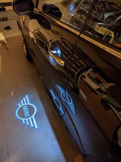 The puddle lights of a black MINI Convertible.