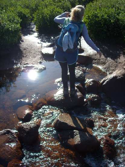 Julie crossing a stream.
