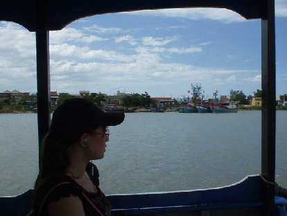 Vietnamese girl listens to MP3s on her Sony Ericson cell phone while looking out the boat from My Son to Hoi An.
