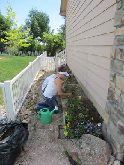 Kelly planting some flowers in my flower garden as a surprise for me on my birthday, with Tim lending her a hand.