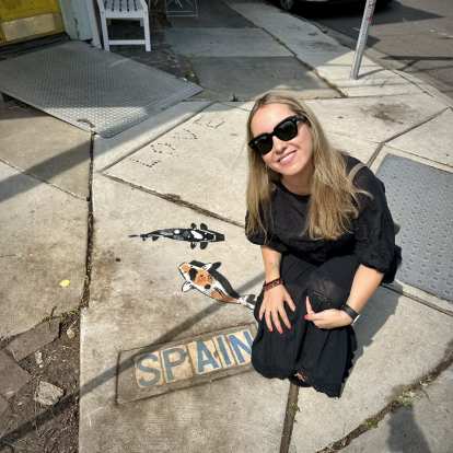 Andrea with a Spain sign on the sidewalk.