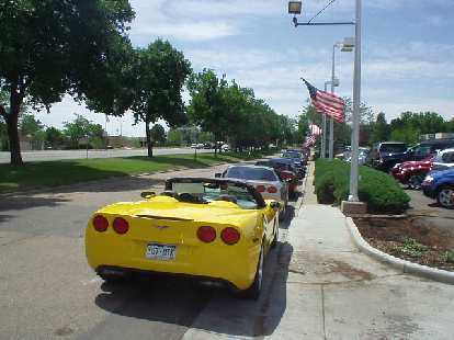 A row of All-American Corvettes with the star-spangled banner flying above.