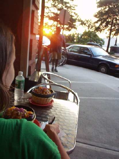 Carolyn with some delicious arroz con pollo in front of the waterfront while Felix Wong sneaks up behind her to snap this photo.