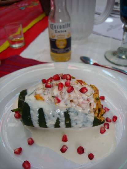 Chile de nogada with a cream and pomegranite seeds on top. The small bottle of Corona was labeled Coronita.