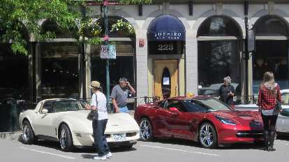 A white 1970s era Corvette Coupe with a dark red 2015 Corvette Stingray. white 1970s era Corvette Coupe with dark red 2015 Corvette Stingray